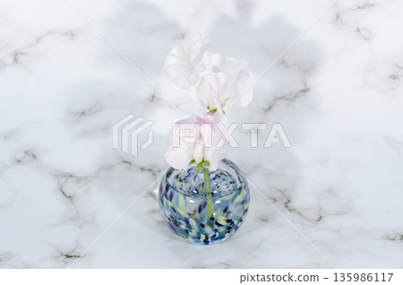 Sweet peas in a cool-colored glass vase (center position) Sweet peas in a cool-colored glass vase (center position) 135986117