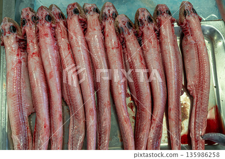 Freshly prepared fish displayed neatly on a metal tray in a market setting Freshly prepared fish displayed neatly on a metal tray in a market setting 135986258