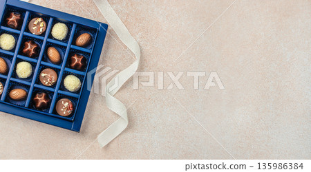 Luxury chocolate assortment in blue gift box with ribbon and copy space Luxury chocolate assortment in blue gift box with ribbon and copy space 135986384