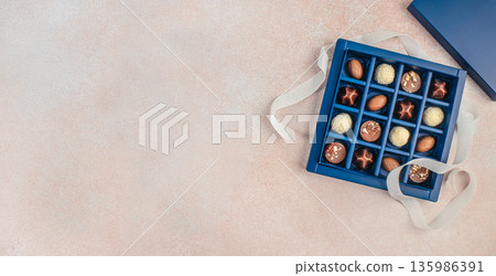 Chocolate gift box with assorted pralines on light background and copy space Chocolate gift box with assorted pralines on light background and copy space 135986391