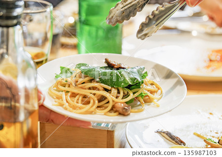 義大利麵配大量芝麻菜和蘑菇，淋上油醬 135987103
