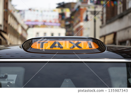 Close-up of Iconic London Black Cab Taxi Sign on City Street Close-up of Iconic London Black Cab Taxi Sign on City Street 135987343