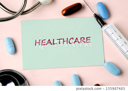 A light green card prominently displays HEALTHCARE in red, surrounded by essential medical items A light green card prominently displays HEALTHCARE in red, surrounded by essential medical items 135987483