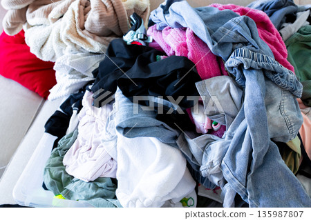 Pile of colorful clothes on fabric surface in disorderly arrangement 135987807