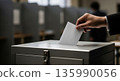 Putting a vote into a ballot box at a polling station on election day 135990056