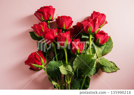Valentine's Day background. Red roses flowers in heart shaped bouquet over pink background. Abstract flat lay. Celebrate, festive greeting card. Valentine's Day background. Red roses flowers in heart shaped bouquet over pink background. Abstract flat lay. Celebrate, festive greeting card. 135990218
