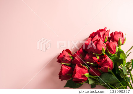 Valentine's Day background. Red roses flower bouquet over pink background. Abstract flat lay. Celebrate, festive greeting card. Valentine's Day background. Red roses flower bouquet over pink background. Abstract flat lay. Celebrate, festive greeting card. 135990237