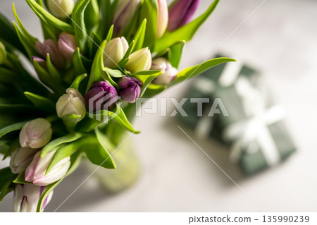Spring floral background. Fresh tulips flowers bouquet and gift boxes. Mother's day. Macro photography 135990239