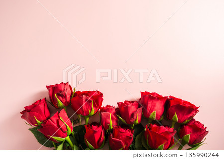Valentine's Day background. Red roses flower bouquet over pink background. Abstract flat lay. Festive greeting card. Valentine's Day background. Red roses flower bouquet over pink background. Abstract flat lay. Festive greeting card. 135990244