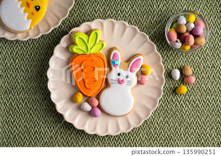 Easter festive colourful cookies bunny, carrot, egg, chick in a plate with egg candies. 135990251