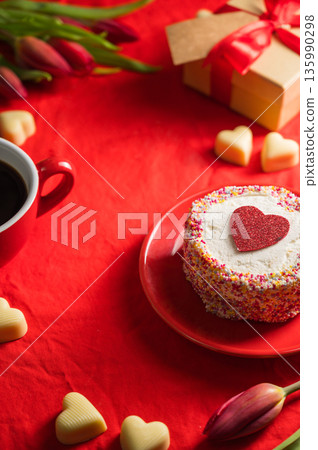 Valentine's Day frame. Cake with red heart, cup of coffee, gift box, heart chocloales and spring red tulip flower bouquet. Top view 135990298