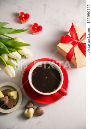 Valentine's day. Cup of coffee, heart chocolates, gift box, heart candles and spring white tulip flower bouquet. Mother's day Valentine's day. Cup of coffee, heart chocolates, gift box, heart candles and spring white tulip flower bouquet. Mother's day 135990325
