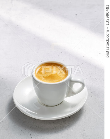 A serene coffee set with one cup on a saucer on a stone under the gentle sunlight A serene coffee set with one cup on a saucer on a stone under the gentle sunlight 135990483