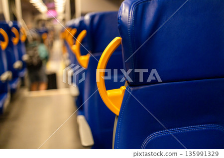 View inside an empty Dutch train driving in the Netherlands in the evening. View inside an empty Dutch train driving in the Netherlands in the evening. 135991329