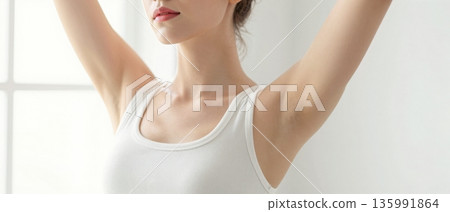 Minimal portrait of young woman stretching arms up in white tank top with soft natural light wellness concept 135991864