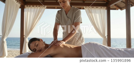 Luxury open air beachfront spa with professional massage therapy in serene ocean setting 135991896