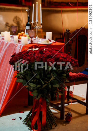 Romantic Valentine's Day Dinner Setup with Red Roses, Candlelight, and Elegant Table Decor Romantic Valentine's Day Dinner Setup with Red Roses, Candlelight, and Elegant Table Decor 135992361