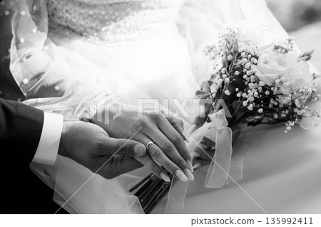 Black and White Wedding Portrait of Bride and Groom Holding Hands with Bouquet and Rings Black and White Wedding Portrait of Bride and Groom Holding Hands with Bouquet and Rings 135992411