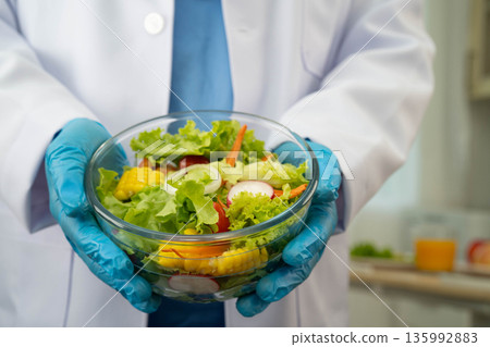 Asian Nutritionist holding healthy food for patient in hospital, nutrition and vitamin. Asian Nutritionist holding healthy food for patient in hospital, nutrition and vitamin. 135992883