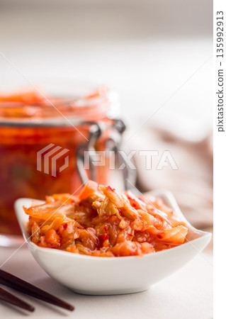 Fermented cabbage. Kimchi. Korean food in bowl on white table. 135992913