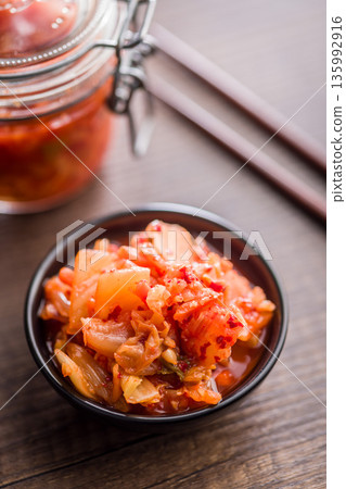 Fermented cabbage. Kimchi. Korean food in bowl on wooden table. 135992916