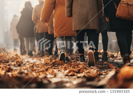 Diverse Group of People Walking Among Leaves in a Sunlit Autumn Atmosphere Diverse Group of People Walking Among Leaves in a Sunlit Autumn Atmosphere 135993385