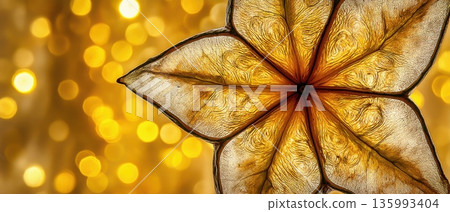 Abstract Close-Up of Glowing Starfruit Cross Section with Golden Background and Bokeh Effect 135993404