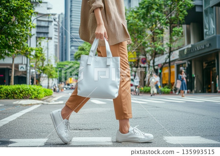 Stylish Woman Walking in City with Unbranded White Tote Bag Stylish Woman Walking in City with Unbranded White Tote Bag 135993515