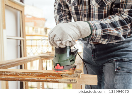 Carpenter at work, restoring an old wooden window. Carpentry. Carpenter at work, restoring an old wooden window. Carpentry. 135994070