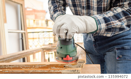 Carpenter at work, restoring an old wooden window. Carpentry. 135994072