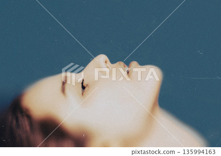 Woman dreaming with closed eyes portraying serenity 135994163