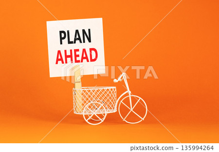Plan ahead symbol. Concept word Plan ahead on beautiful white paper. Beautiful wooden clothespin. Miniature white bicycle. Beautiful orange background. Business plan ahead concept. Copy space. Plan ahead symbol. Concept word Plan ahead on beautiful white paper. Beautiful wooden clothespin. Miniature white bicycle. Beautiful orange background. Business plan ahead concept. Copy space. 135994264