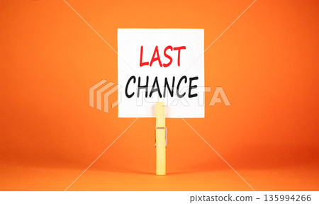 Last chance symbol. Concept word Last chance on beautiful white paper. Beautiful wooden clothespin. Beautiful orange background. Business last chance concept. Copy space. Last chance symbol. Concept word Last chance on beautiful white paper. Beautiful wooden clothespin. Beautiful orange background. Business last chance concept. Copy space. 135994266
