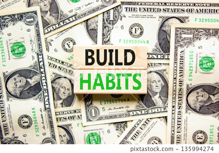 Build habits symbol. Concept word Build habits on beautiful wooden blocks. Dollar bills. Beautiful dollar bills background. Business build habits concept. Copy space. 135994274