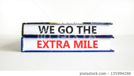 Support, help we go the extra mile symbol. Concept words We go the extra mile on beautiful books. Beautiful white paper background. Business we go the extra mile concept. Copy space. Support, help we go the extra mile symbol. Concept words We go the extra mile on beautiful books. Beautiful white paper background. Business we go the extra mile concept. Copy space. 135994286