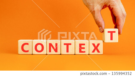Context symbol. Concept word Context on beautiful wooden blocks. Beautiful orange background. Businessman's hand. Business context concept. Copy space. 135994352