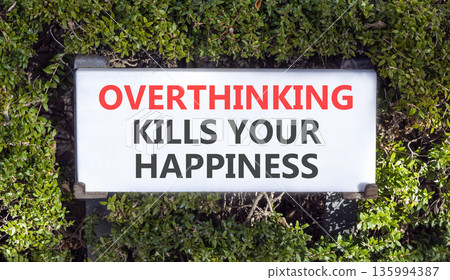 Overthinking kills your happiness symbol. Concept words Overthinking kills your happiness on road sign. Beautiful green trees background. Business overthinking kills happiness concept. Copy space. 135994387