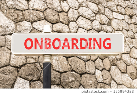 Onboarding success symbol. Concept word Onboarding on beautiful grey road sign. Beautiful stone wall background. Business onboarding success concept. Copy space. Onboarding success symbol. Concept word Onboarding on beautiful grey road sign. Beautiful stone wall background. Business onboarding success concept. Copy space. 135994388