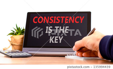 Consistency is the key symbol. Concept words Consistency is the key on beautiful black tablet. Beautiful white background. Businessman's hand. Business consistency is the key concept. Copy space. 135994439