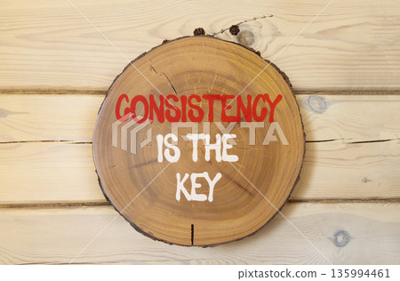 Consistency is the key symbol. Concept words Consistency is the key on beautiful wooden circle. Beautiful wooden wall background. Business consistency is the key concept. Copy space. 135994461