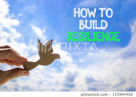 How to build resilience symbol. Concept words How to build resilience on beautiful blue sky. Beautiful blue sky background. Businessman's hand. Business how to build resilience concept. Copy space. How to build resilience symbol. Concept words How to build resilience on beautiful blue sky. Beautiful blue sky background. Businessman's hand. Business how to build resilience concept. Copy space. 135994488