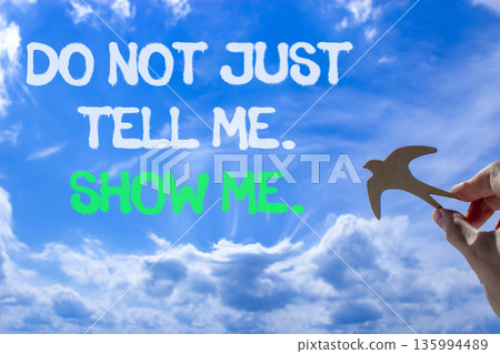 Tell or show symbol. Concept words Do not just tell me, show me on beautiful blue sky. Beautiful blue sky background. Businessman's hand with wooden bird. Business tell or show concept. Copy space. Tell or show symbol. Concept words Do not just tell me, show me on beautiful blue sky. Beautiful blue sky background. Businessman's hand with wooden bird. Business tell or show concept. Copy space. 135994489