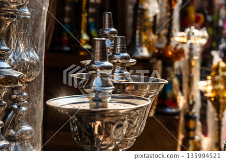 A shop in Khan El Khalili market, Cairo, is selling colourful shisha pipes. The entrance displays various ornate shisha, showcasing traditional Egyptian craftsmanship. A shop in Khan El Khalili market, Cairo, is selling colourful shisha pipes. The entrance displays various ornate shisha, showcasing traditional Egyptian craftsmanship. 135994521