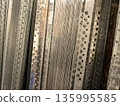 Metal strips with holes showcased in a bright storage facility 135995585