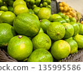 Fresh limes piled high in a vibrant market display 135995586