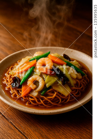 Close-up of thick fried noodles with toppings 135995635
