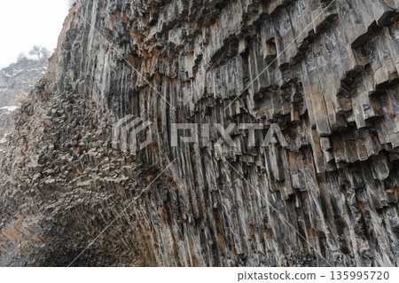 Vertical basalt columns form dense geometric textures along cliff face of Symphony of Stones, layered volcanic rock creates striking natural pattern 135995720