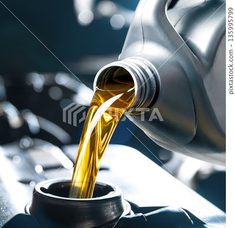 Pouring engine oil into car engine 135995799