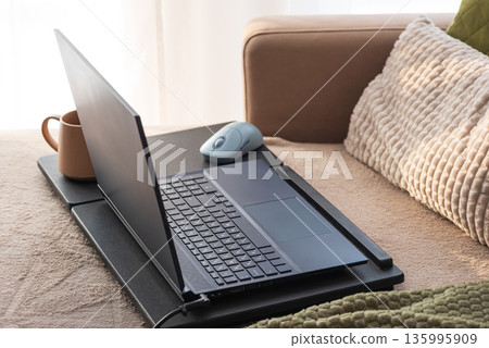 Laptop and Coffee Mug on Lap Desk. Cozy Morning Home Workspace with Green Accents 135995909