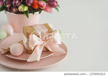 Easter Table Setting with Gift Box, Decorated Eggs and Tulips. Festive Spring Lifestyle Easter Table Setting with Gift Box, Decorated Eggs and Tulips. Festive Spring Lifestyle 135995922